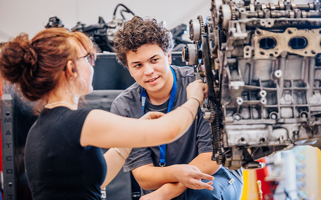Career and technical education student working on engine